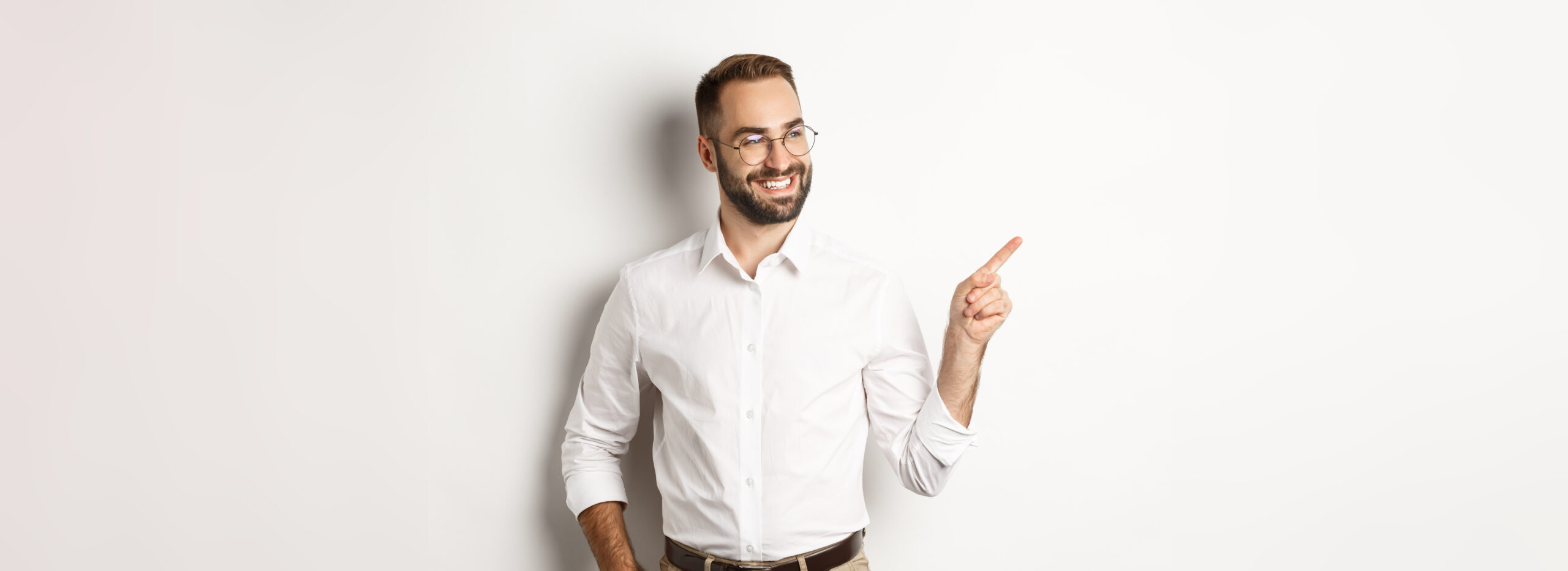 Selbstbewuster businessman sieht gluecklich aus zeigt mit dem finger links
