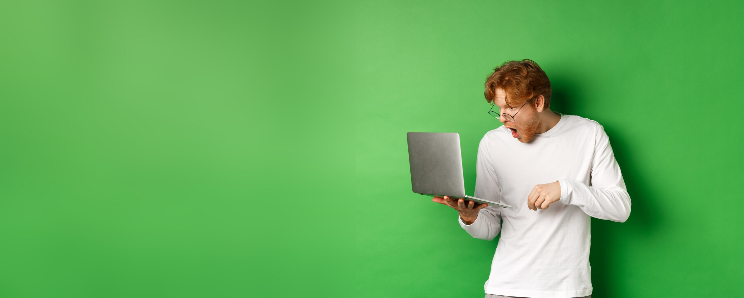 junger man schaut auf sein laptop bildschirm begeistert