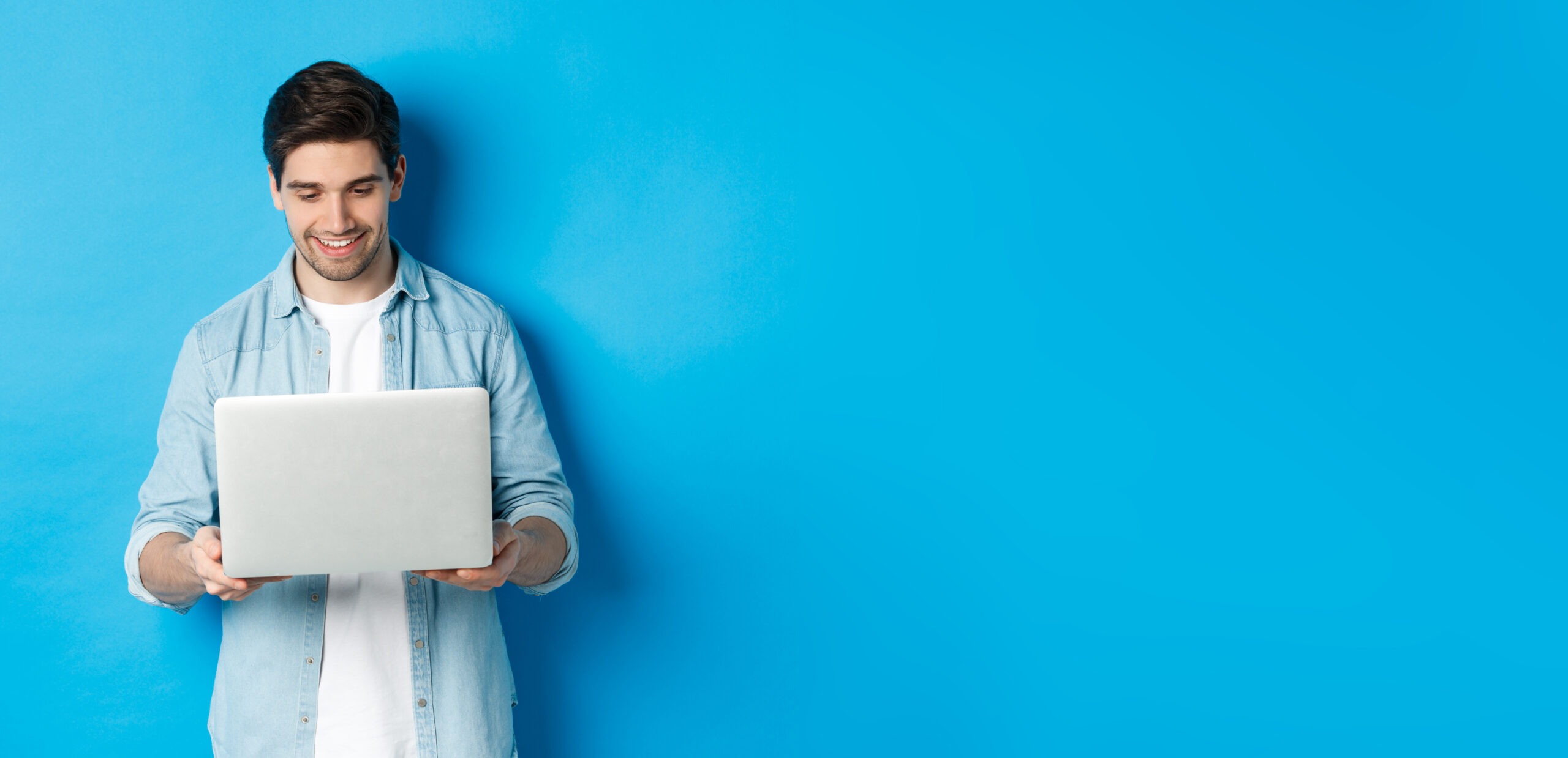 Junger web designer schaut auf sein laptop