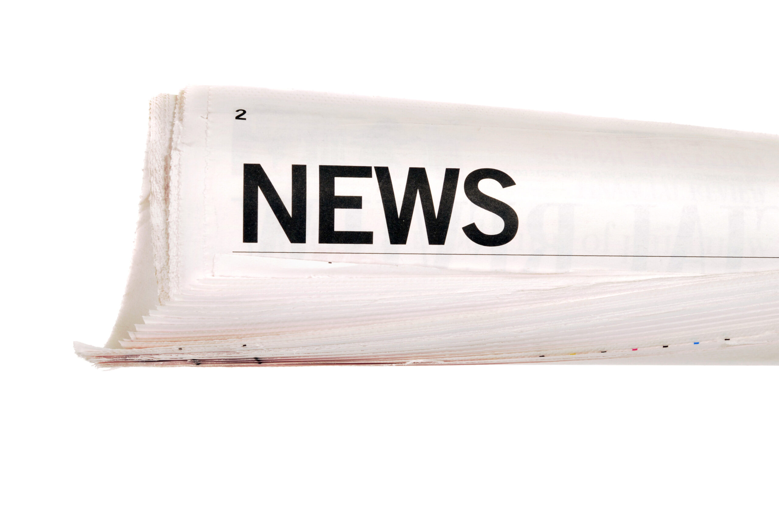 Rolled up newspaper with news headline set against a white background