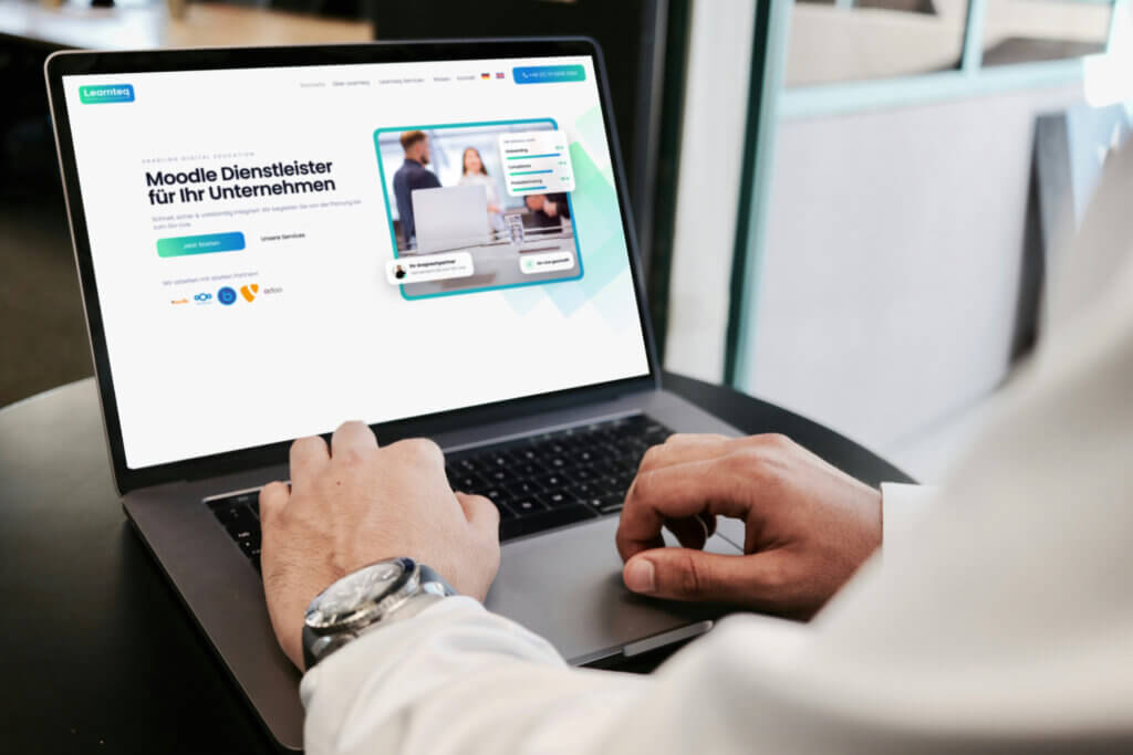 Person arbeitet am Laptop auf der Learnteq-Website mit dem Titel „Moodle Dienstleister für Ihr Unternehmen“